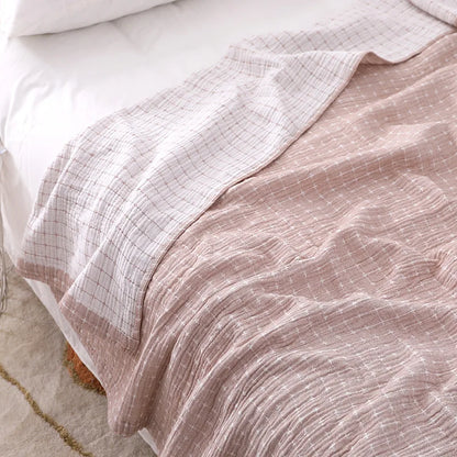 Rosa-weiß kariertes Bettlaken aus Baumwolle auf einem Bett, gemütlich und stilvoll.