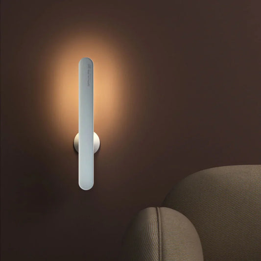 Moderne LED-Wandleuchte, vertikal, silber, warmweißes Licht, minimalistisches Design.