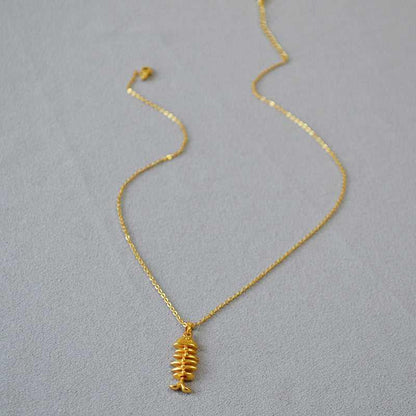Goldene Halskette mit Fischgräten-Anhänger, eleganter Schmuck, modisches Accessoire.