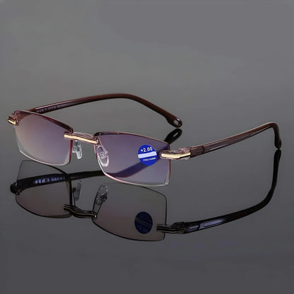 Randlose Lesebrille in der braunen Bügelvariante mit goldfarbenen Scharnieren auf spiegelnder grauer Fläche. 7