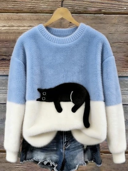 Flauschiger Pullover in Hellblau und Weiß mit aufgesetzter schwarzer Katze, am Holzbügel vor Jeansshorts 1