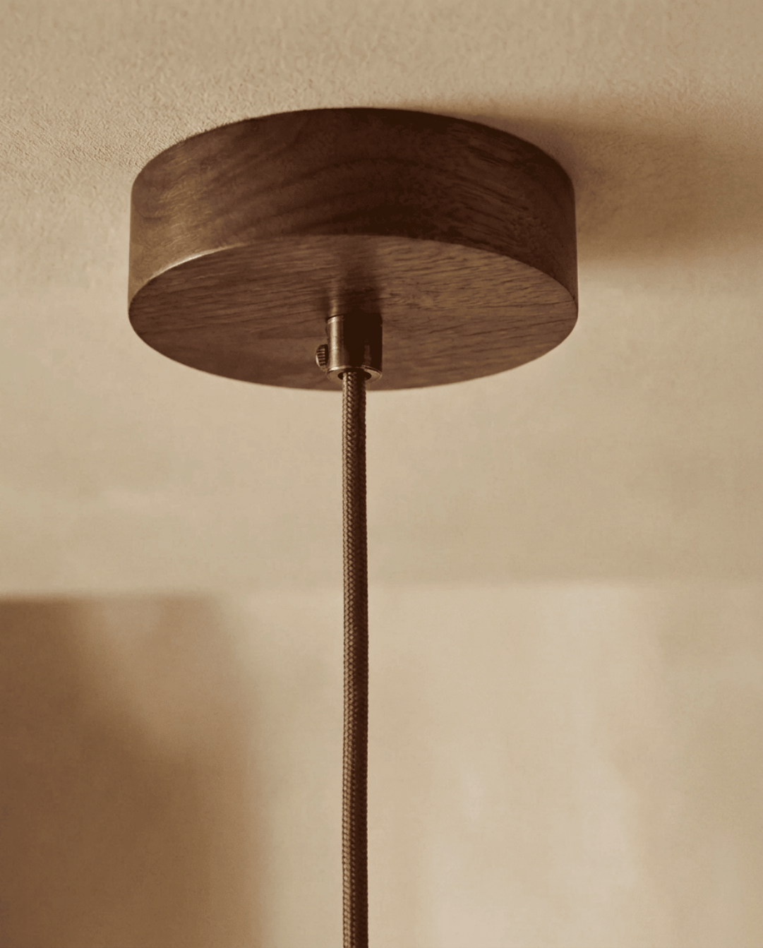 Detail der runden Deckenhalterung aus dunklem Holz mit Kabelklemme und geflochtenem Textilkabel 5