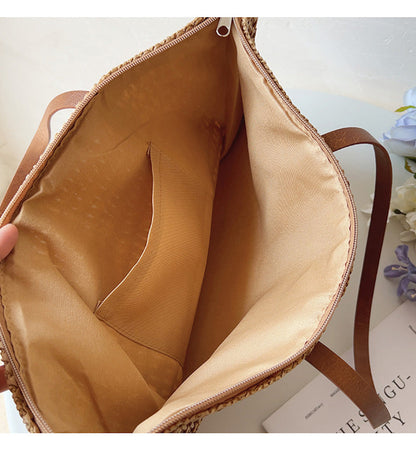 Geflochtene Damenhandtasche aus Stroh, beige Innenfutter, braune Griffe, Sommermode.