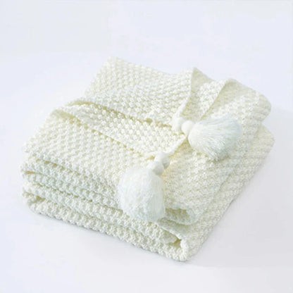 Weiße gestrickte Decke mit Quasten, weiche Baumwolle, gemütliche Wohnaccessoires.