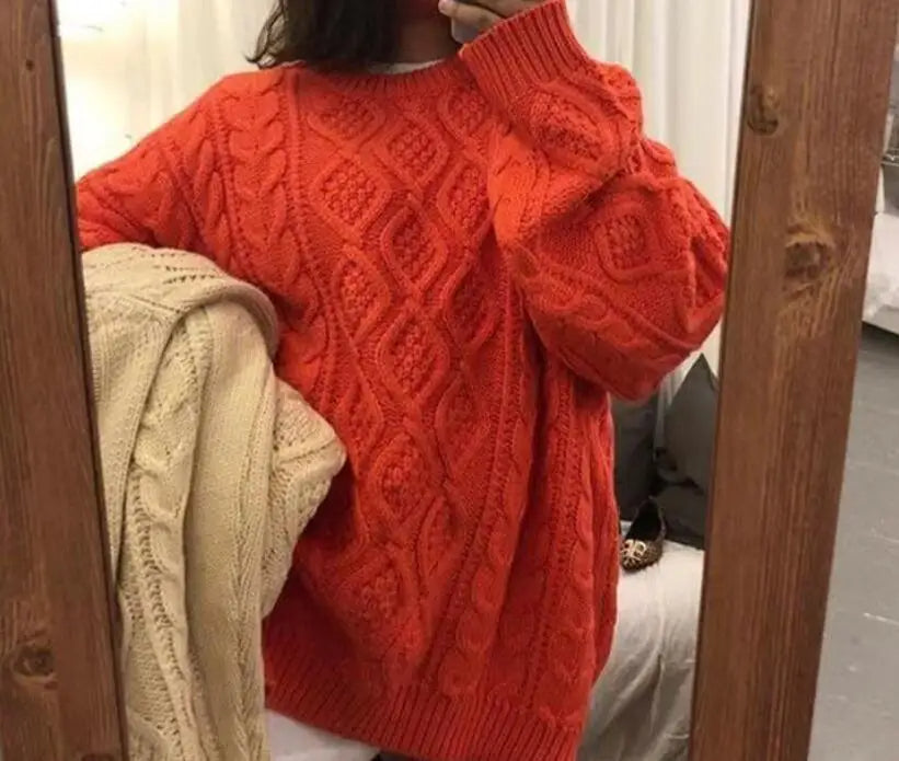 Frau in rotem Strickpullover mit Zopfmuster, hält beigen Pullover, gemütliche Wintermode.