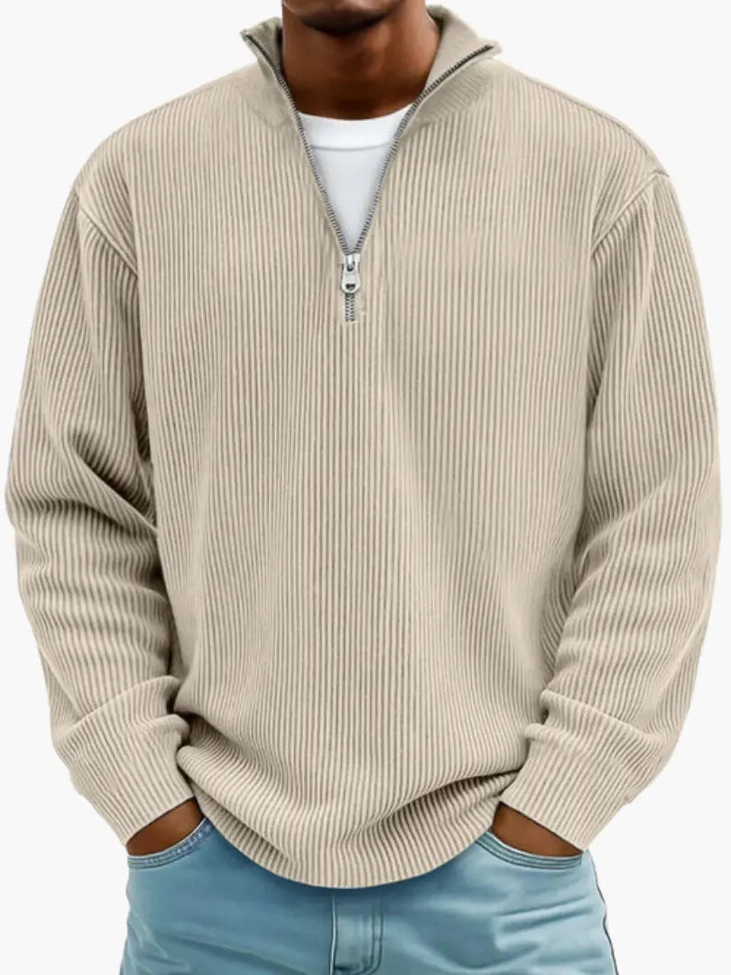 Frontansicht des gerippten Zip-Pullovers in Beige, getragen über einem weißen Shirt mit hellblauer Jeans. 4