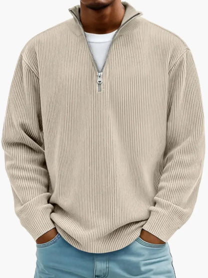 Frontansicht des gerippten Zip-Pullovers in Beige, getragen über einem weißen Shirt mit hellblauer Jeans. 4
