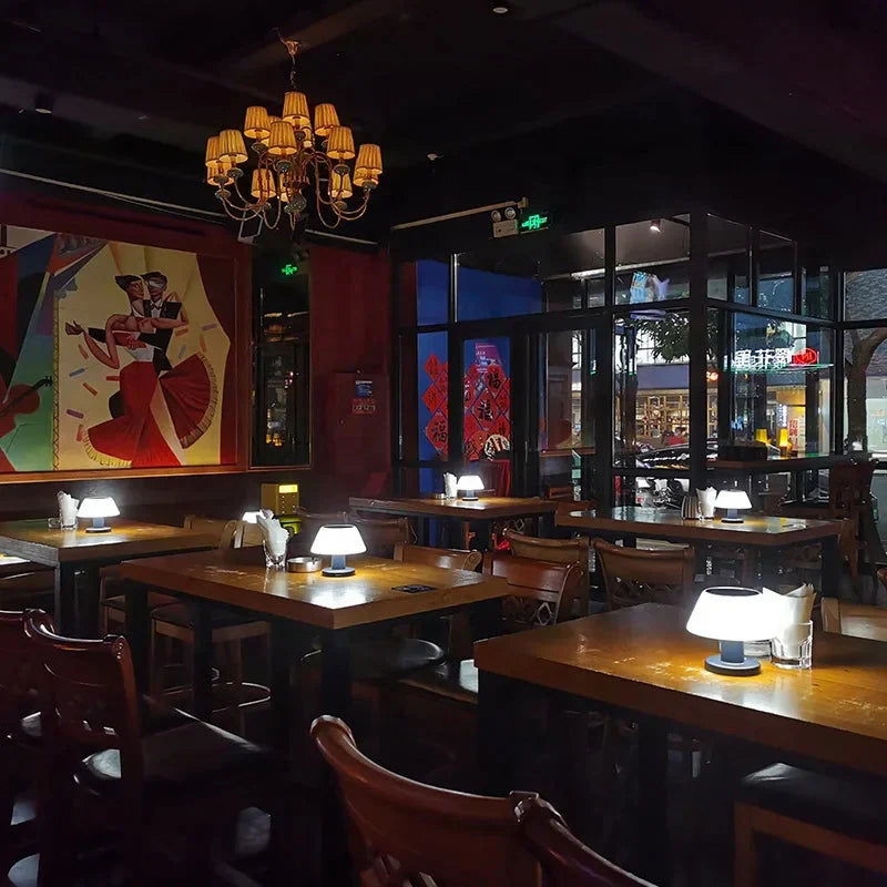 Gemütliches Restaurant mit Holztischen, modernen Tischlampen und farbenfroher Wandkunst.