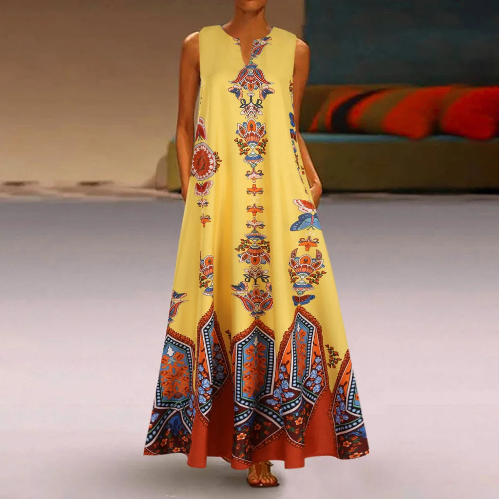 Frau in gelbem Maxikleid mit buntem Ethno-Muster, ärmellos, Sommermode, Boho-Stil.
