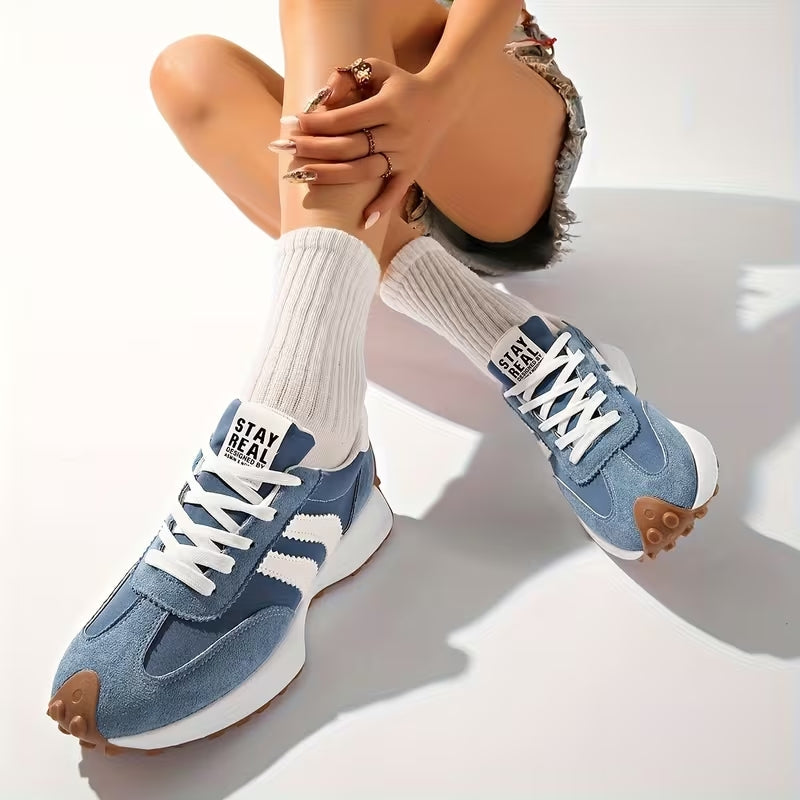 Blaue Sneaker mit weißen Streifen, getragen zu weißen Rippensocken, Model sitzt mit angezogenen Beinen 9