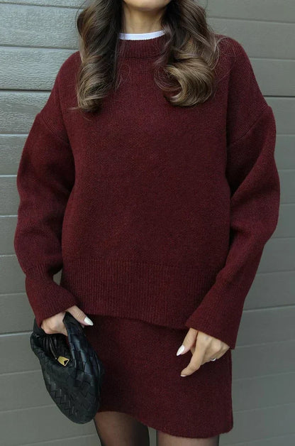 Nahaufnahme des weinroten Strickpullovers mit Rundhals, gerippten Bündchen und dem Rockansatz, Stoffstruktur gut erkennbar. 4