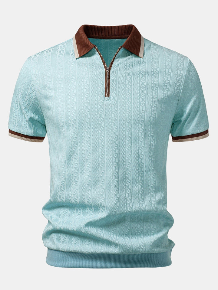 Vorderansicht des hellblauen Poloshirts mit Zopfmuster, braunem Kragen, Reißverschluss und braun-beige gestreiften Ärmelbündchen. 9