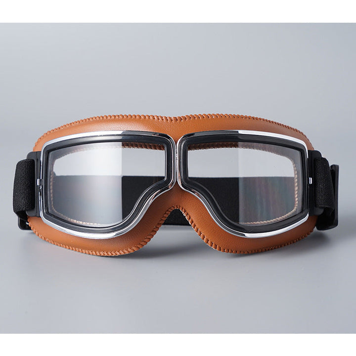 Fliegerbrille mit hellbrauner Lederpolsterung, Chromrahmen und klaren Gläsern, Vorderansicht mit schwarzem Band. 7