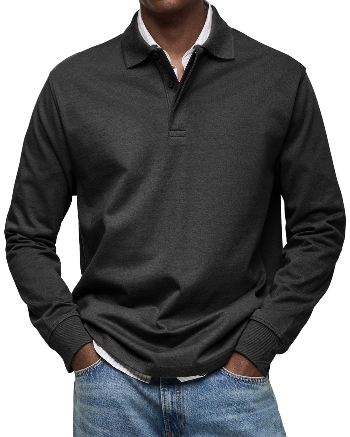 Langarm-Poloshirt in Schwarz von vorn am Model, kombiniert mit Jeans und einem gestreiften Hemd als Unterlage. 4