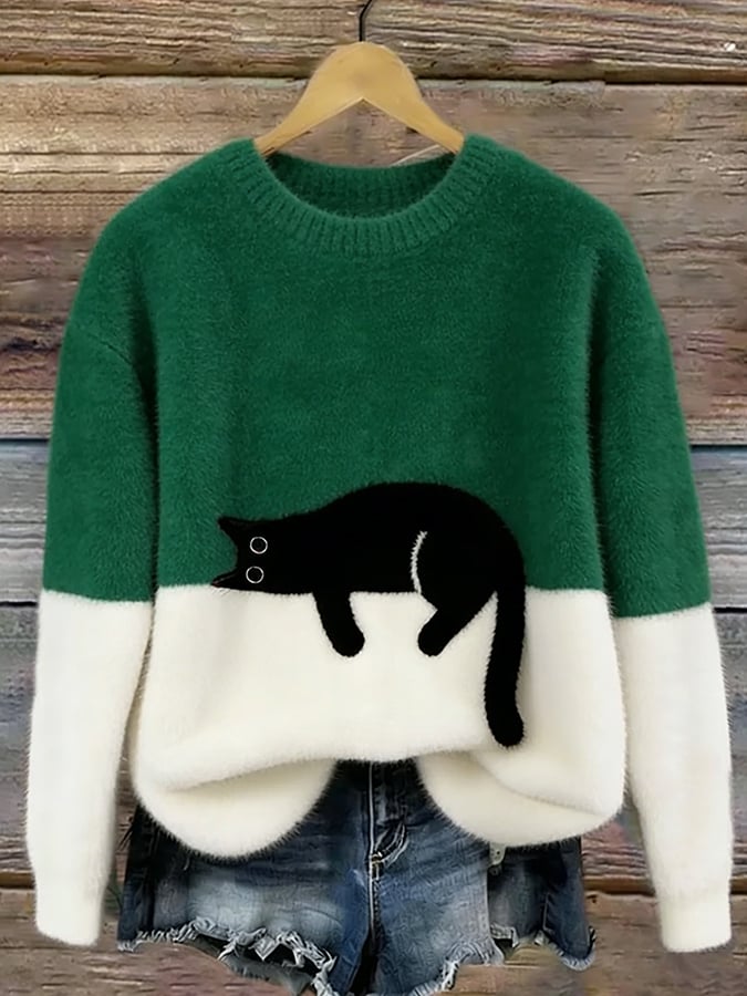 Flauschiger Pullover in Dunkelgrün und Weiß mit schwarzer Katze, am Holzbügel vor Jeansshorts 4