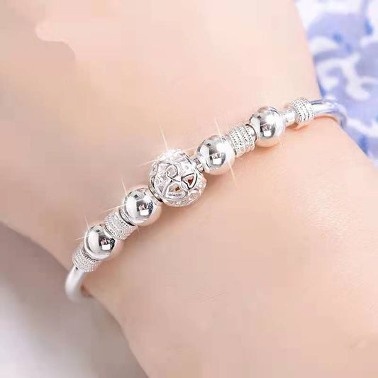 Silberarmband mit glänzenden Kugeln und filigranem Design, eleganter Schmuck für Damen.