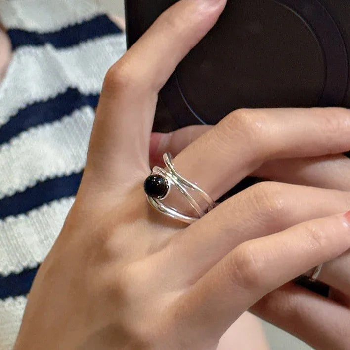 Silberring mit schwarzem Stein, elegantes Design, Damenmode, Schmuckaccessoire, Nahaufnahme.