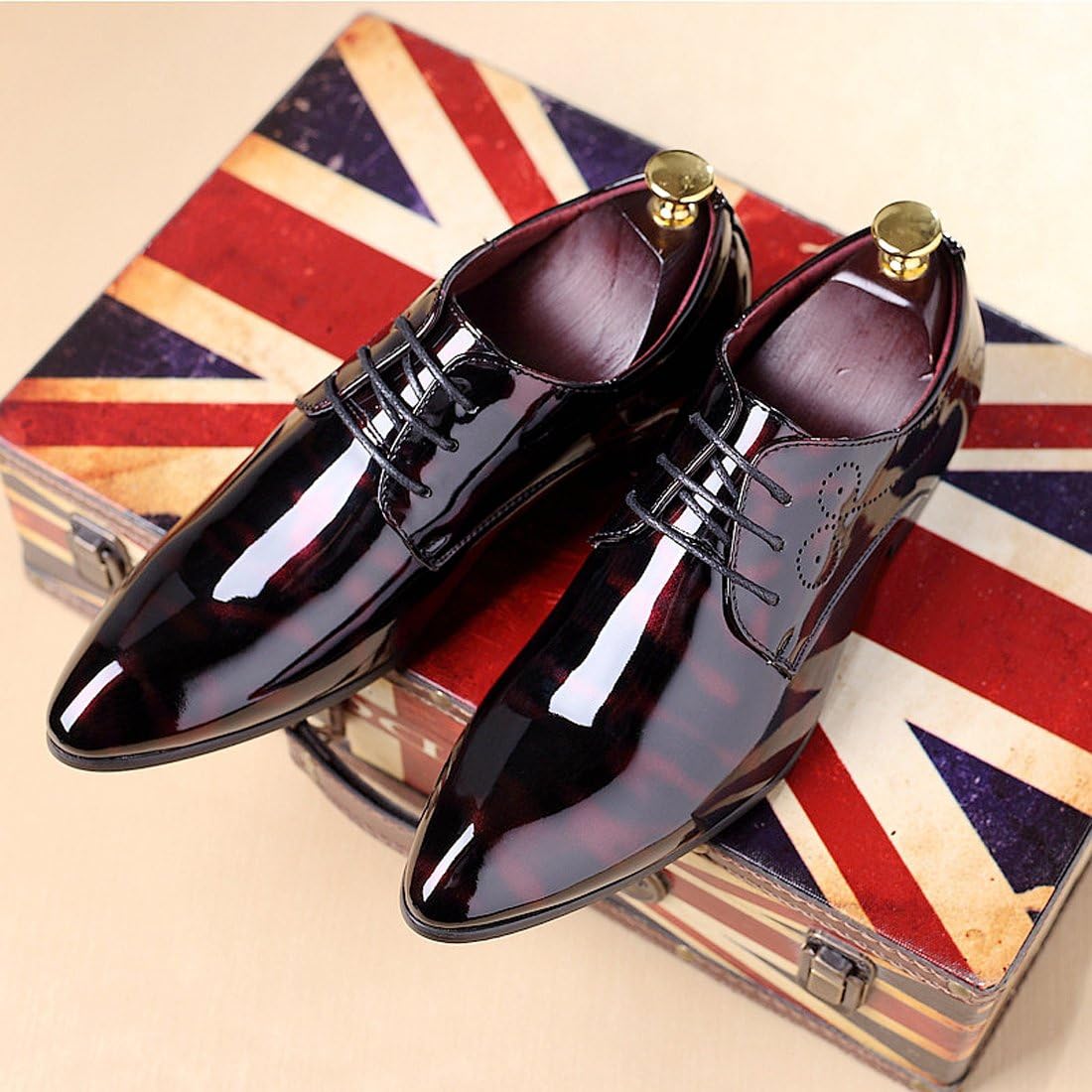 Schwarze Lacklederschuhe für Herren auf britischem Koffer, elegant und stilvoll.