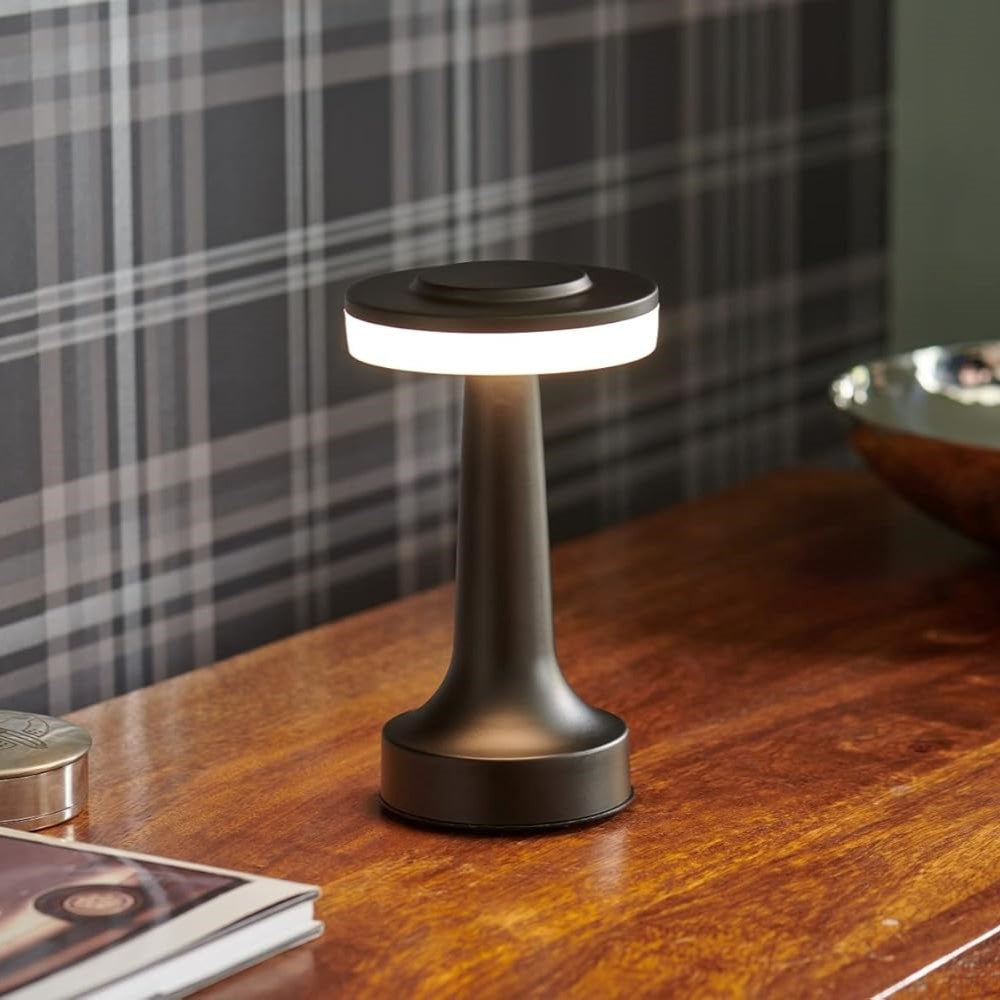 Moderne schwarze LED-Tischlampe auf Holzoberfläche, energiesparend, stilvolles Design.