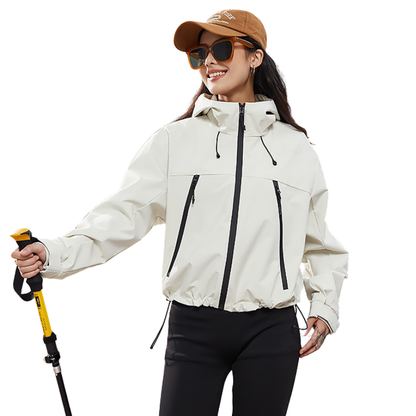 Frau in cremeweißer Jacke mit Kapuze und Kordelzug am Saum, hält lächelnd einen gelben Trekkingstock 3