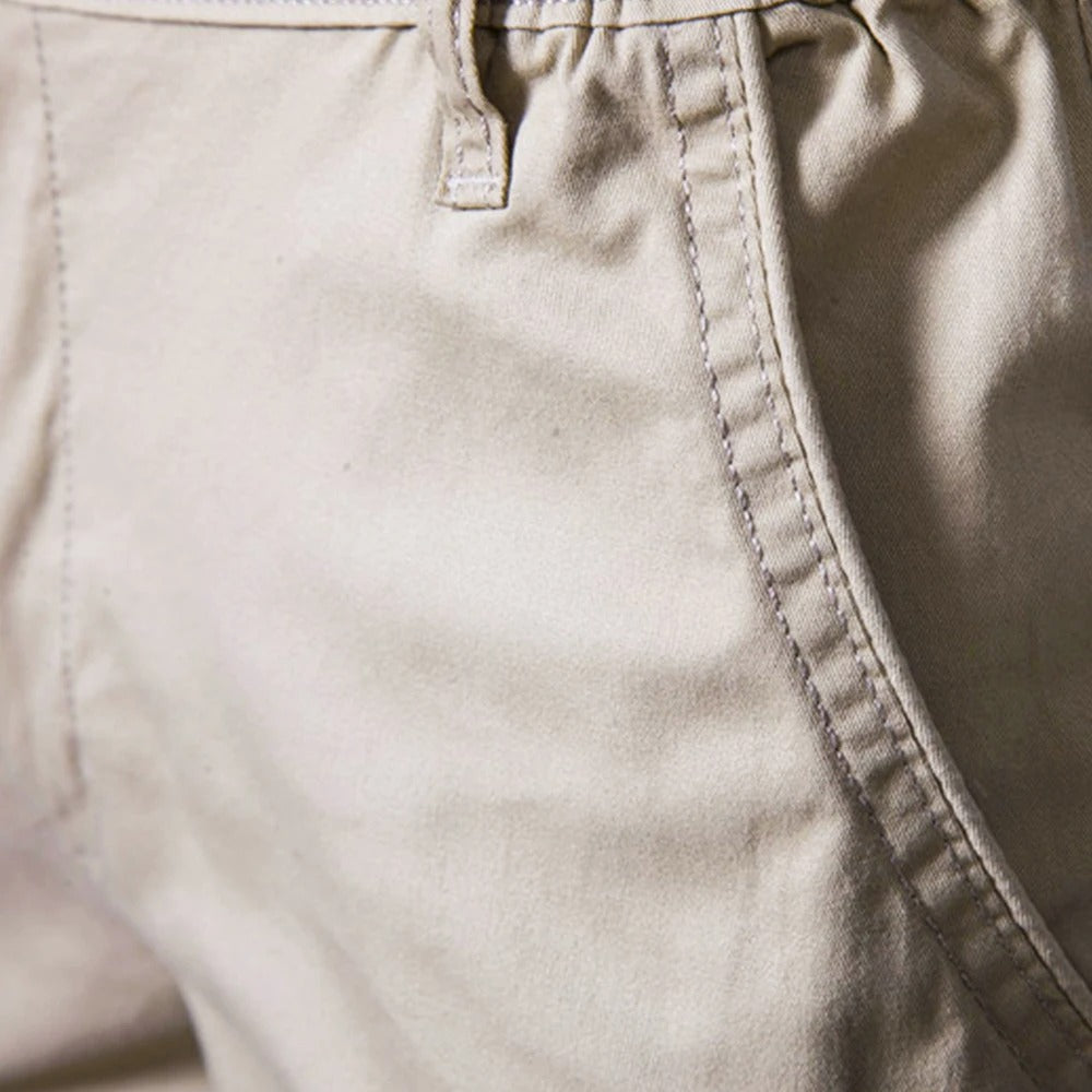 Nahaufnahme der Seitentasche an der beigen Shorts mit Ziernaht, Gürtelschlaufe und Bundansatz. 3