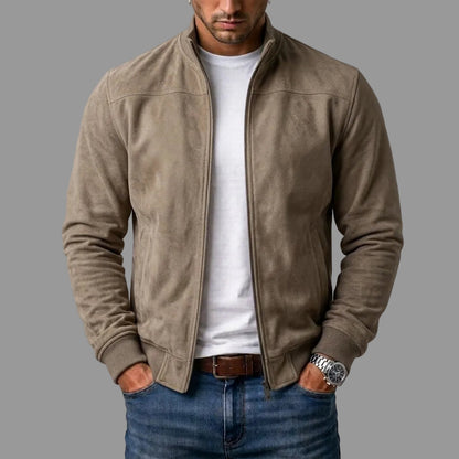 Mann trägt die offene Bomberjacke in hellem Graubraun mit weißem T-Shirt und Jeans, Hände in den Taschen. 2