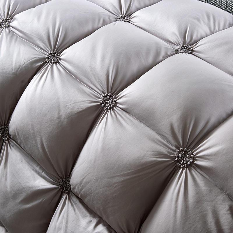 Graues, gestepptes Kopfteil aus Leder mit Knopfdetails, luxuriöses Schlafzimmermöbel.