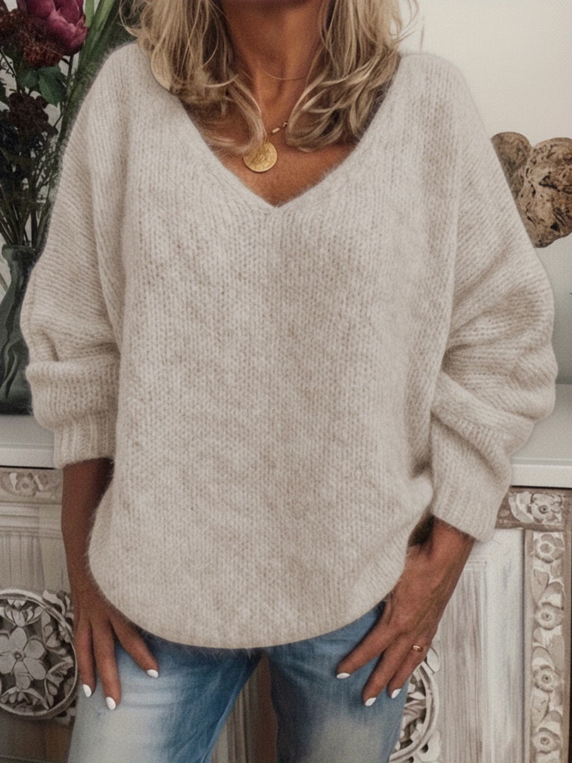 Flauschig wirkender Grobstrickpullover in Cremebeige, getragen zur Jeans, V-Ausschnitt und locker fallende Ärmel mit Bündchen. 4
