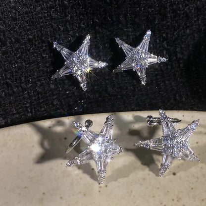 Sternförmige Ohrringe aus Silber mit funkelnden Kristallen auf schwarzem Hintergrund.