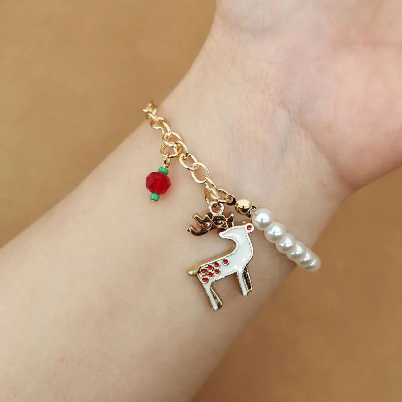 Goldenes Armband mit Rentier-Anhänger, Perlen und rotem Schmuck, modisches Accessoire.