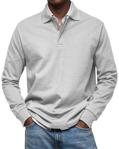 Langarm-Poloshirt in hellem Grau am Model, Hände in den Jeanstaschen, Hemdkragen und Saum des Hemdes sichtbar. 5