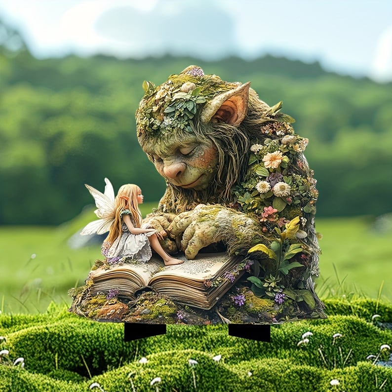 Schlafender, bemooster Troll mit Blumen am Körper, auf dessen Buch eine kleine Fee sitzt, im Moos einer Wiese. 2