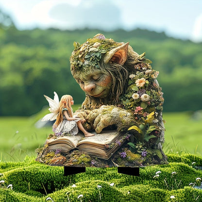Schlafender, bemooster Troll mit Blumen am Körper, auf dessen Buch eine kleine Fee sitzt, im Moos einer Wiese. 2