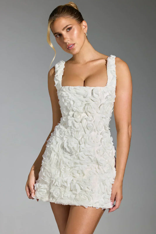Frau in weißem Blumenkleid, ärmellos, figurbetont, elegantes Design, Modefotografie.