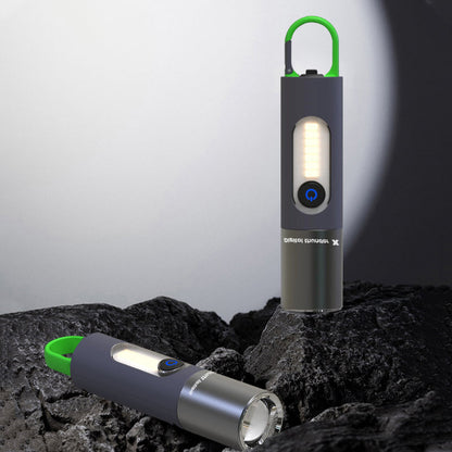 Zwei tragbare LED-Taschenlampen, schwarz mit grünem Griff, auf Felsen im Freien.