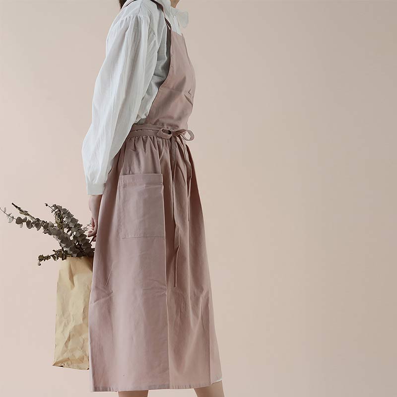 Frau in rosa Schürze mit weißen Hemd, hält Papiertüte mit Eukalyptus, minimalistischer Stil.