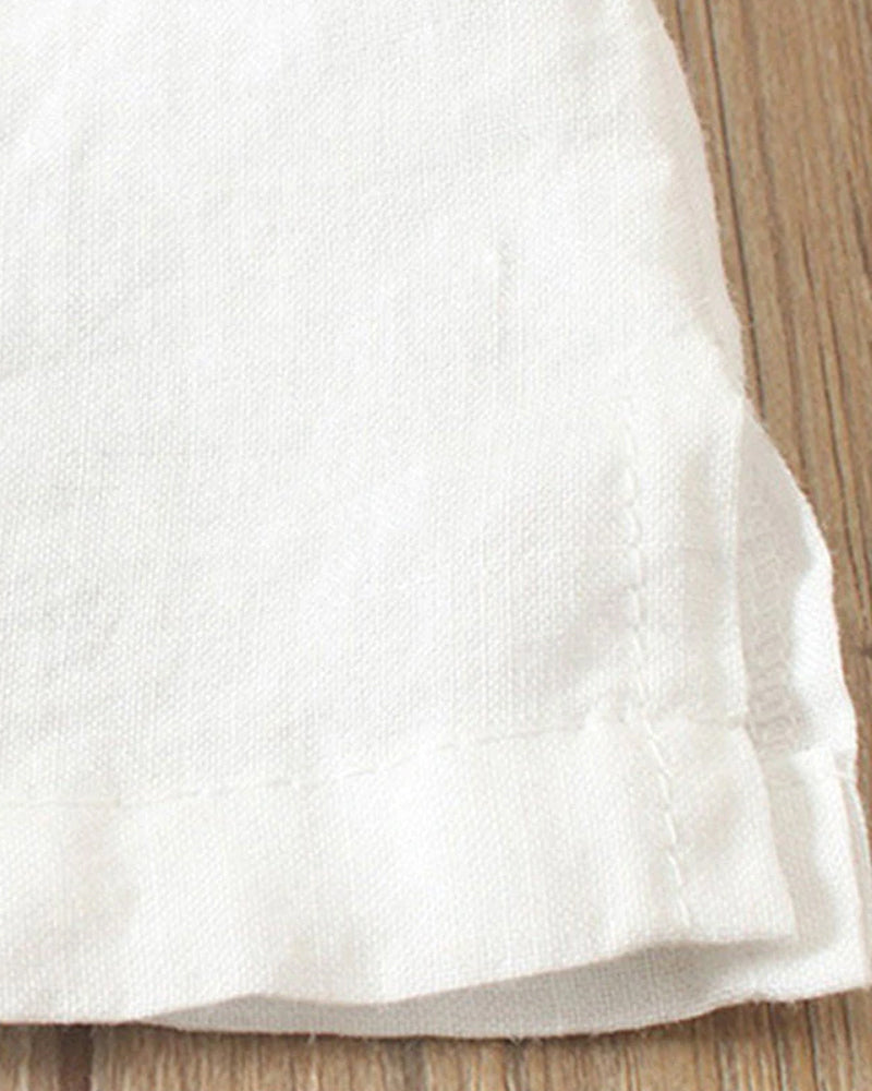 Weiße Leinenserviette auf Holztisch, hochwertig, elegant, ideal für Tischdekoration.