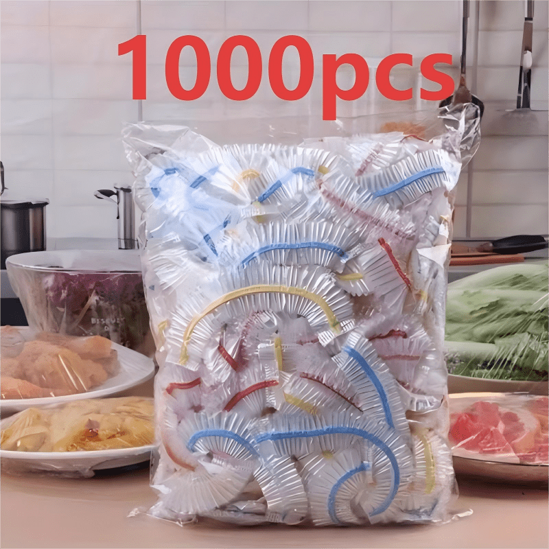 Beutel mit farbigen Abdeckkappen vor einer Küchenzeile, links und rechts abgedeckte Teller mit Fleisch, Nudeln und Salat. 3
