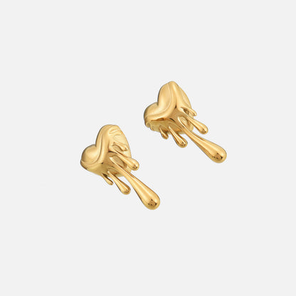 Die goldfarbenen Herz-Ohrstecker mit Tropfen im Schrägblick, der die plastische Form und glänzende Oberfläche zeigt. 2