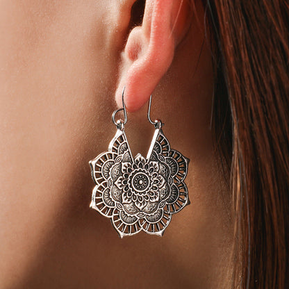 Silberne Mandala-Ohrringe, filigranes Design, Damen-Schmuck, Boho-Stil, Nahaufnahme.