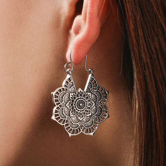Silberne Mandala-Ohrringe, filigranes Design, Damen-Schmuck, Boho-Stil, Nahaufnahme.