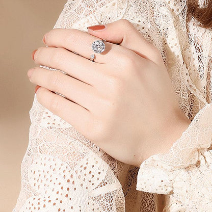 Frau mit elegantem Silberring, großer runder Diamant, Spitzenbluse, stilvoller Schmuck.
