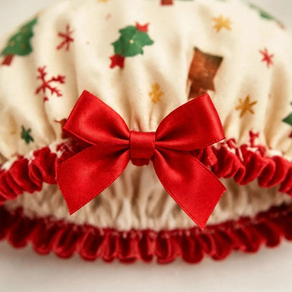Nahaufnahme der cremefarbenen Duschhaube mit Weihnachtsmotiven, roter Satinschleife und rotem Rüschenrand 3