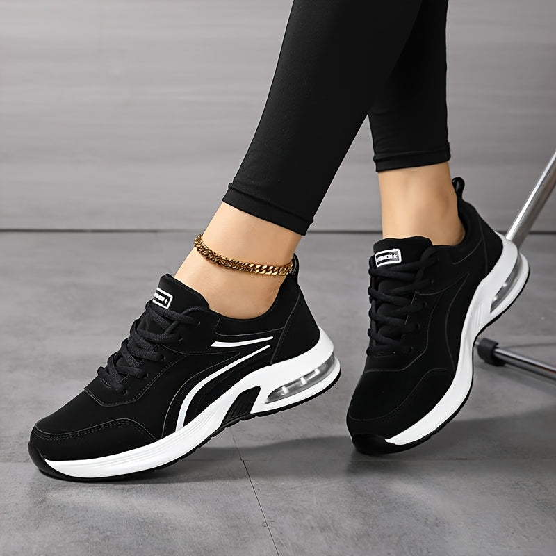 Getragene schwarz-weiße Sneaker mit seitlichen Zierstreifen und Luftpolstersohle, die Füße locker überkreuzt neben einem Stuhlbein. 5