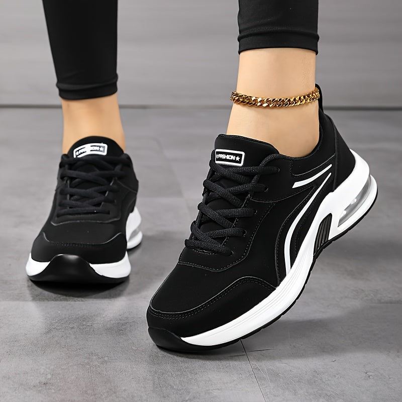 Frontansicht der schwarzen Sneaker mit weißen Zierstreifen und Schnürung, getragen mit schwarzer Leggings und goldener Fußkette. 2