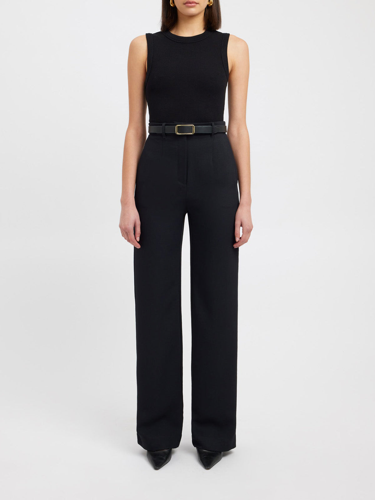 Frau in schwarzem ärmellosen Top und schwarzer Hose, elegantes Outfit, Modefotografie.