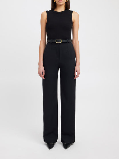 Frau in schwarzem ärmellosen Top und schwarzer Hose, elegantes Outfit, Modefotografie.