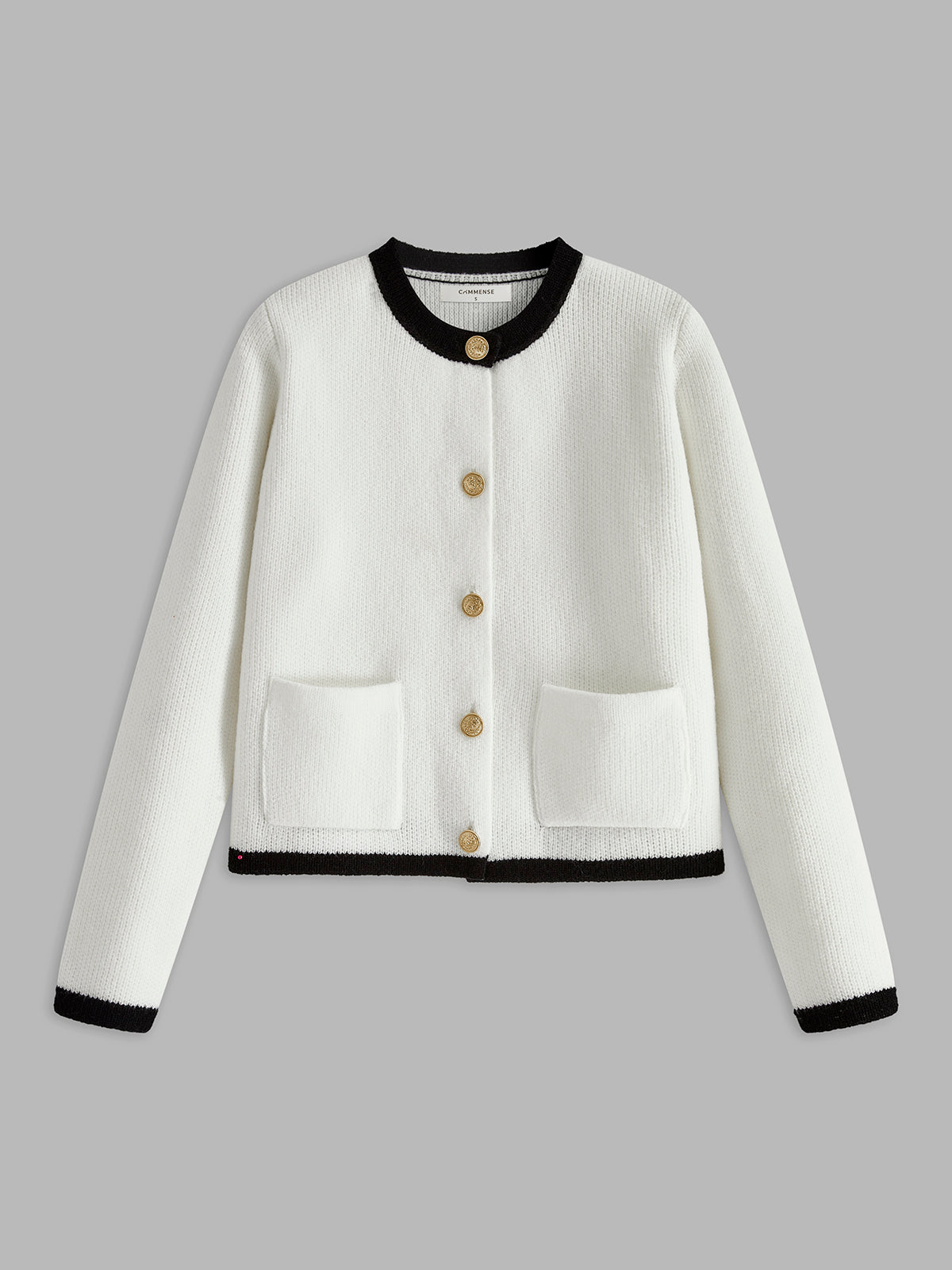 Weiße Strickjacke mit schwarzen Details, goldenen Knöpfen, Taschen, Damenmode, elegant.