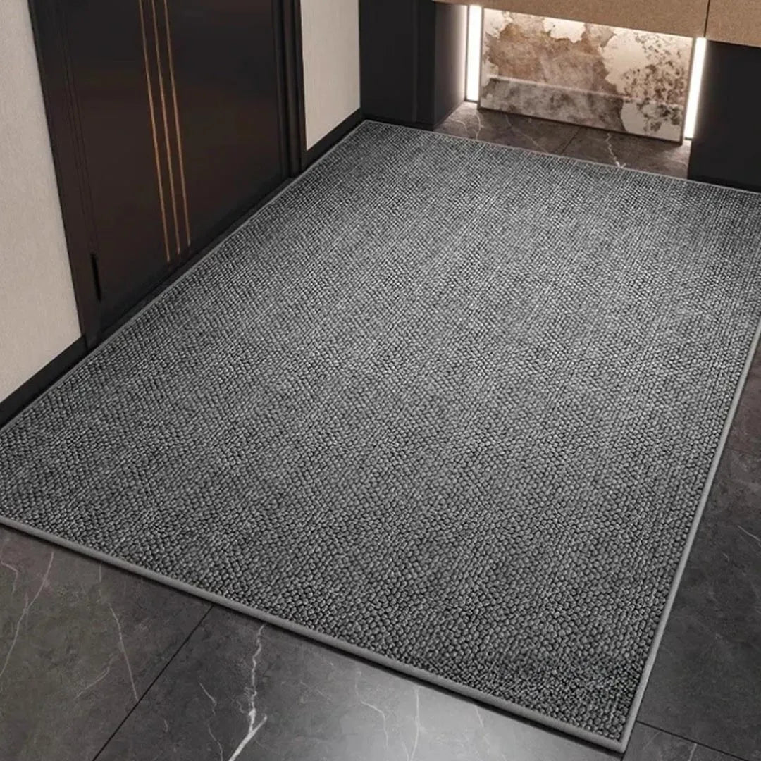 Graue Matte mit Schlingenflor und eingefasster Kante im Eingangsbereich auf dunklem Steinboden 4