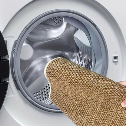 Braune Matte wird zusammengefaltet in die geöffnete Trommel einer Waschmaschine gelegt 7